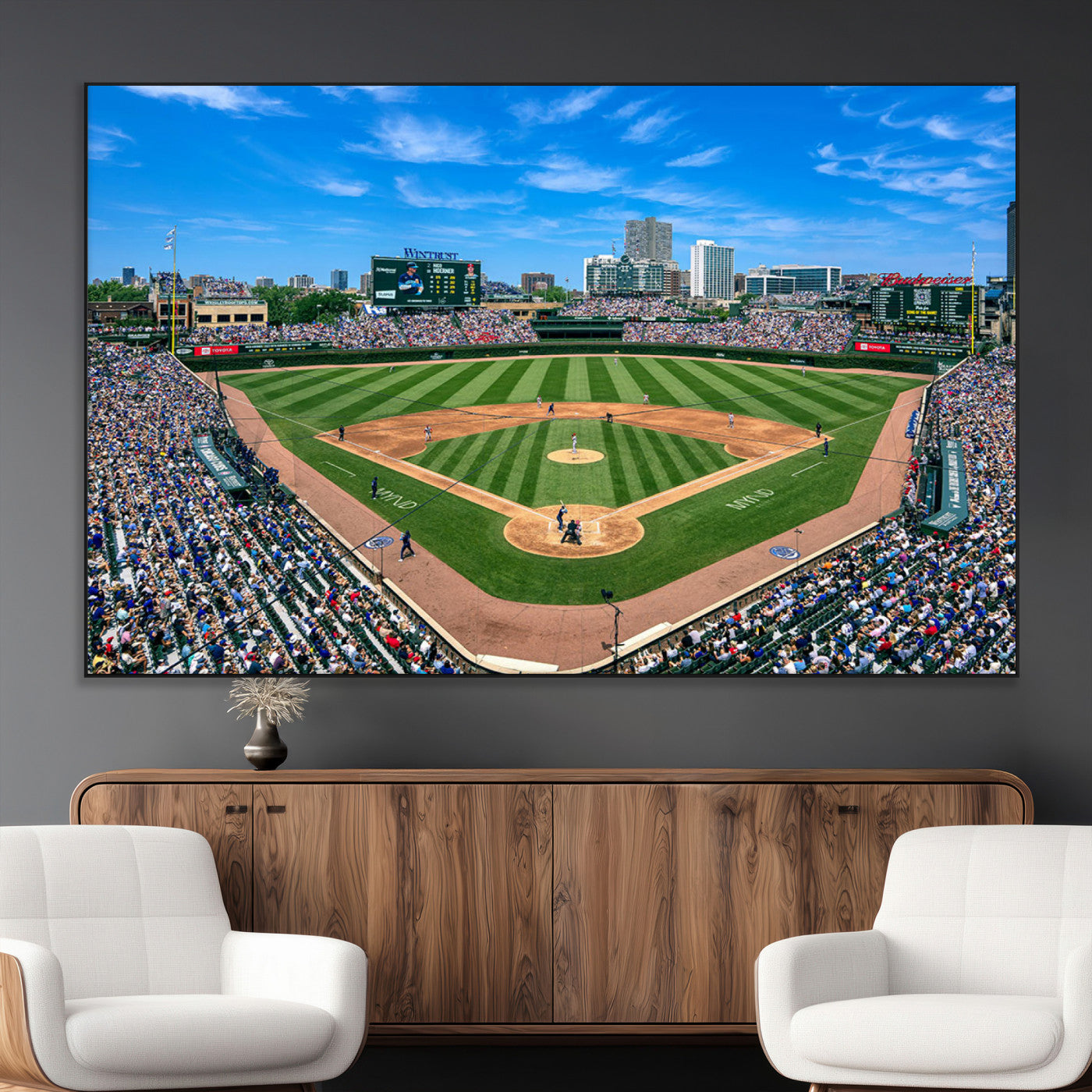 A wide-angle shot of a baseball field filled with spectators, with players on the field and the iconic Wrigley Field scoreboard in the background.