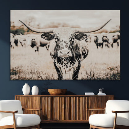 Canvas of a speckled Texas longhorn standing boldly in a field with a herd behind, perfect for rustic western or farmhouse wall decor.