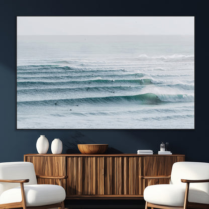 High-angle view of surfers lining up across layered ocean waves, ideal for minimal coastal or surf-inspired room decor.