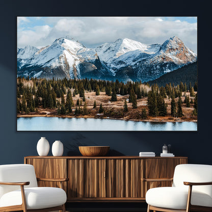 Framed canvas of snowy mountain peaks with pine forest and alpine lake, perfect for winter cabin or wilderness-inspired home decor.