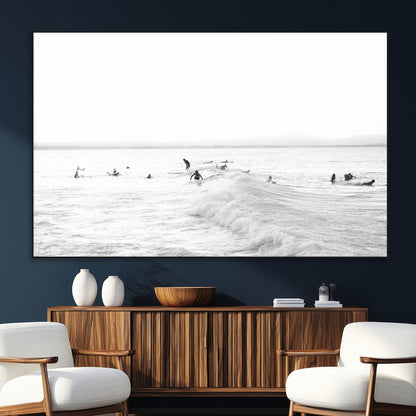 Monochrome photo of surfers riding and waiting on ocean waves, ideal for surf-themed or coastal energy wall decor.