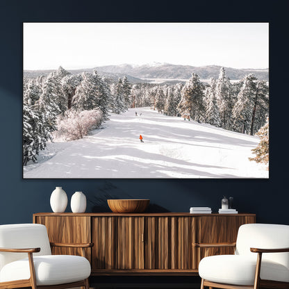 Bright ski trail lined with snow-covered pines and a skier in orange, perfect for alpine adventure or winter sports-inspired decor.
