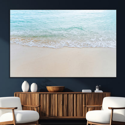 Soft shoreline with gentle aqua waves on smooth sand, ideal for minimalist coastal or pastel ocean-inspired home wall decor.
