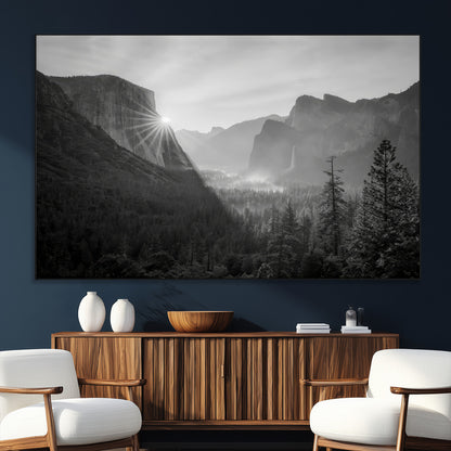 Black and white landscape of Yosemite with sun rays peeking over El Capitan, ideal for moody nature or modern rustic decor.