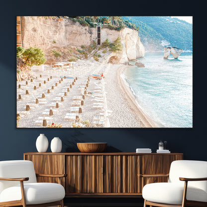 Wall art of a calm Mediterranean beach with rows of sun loungers and umbrellas in soft pastel tones, perfect for light coastal or vacation-themed decor.