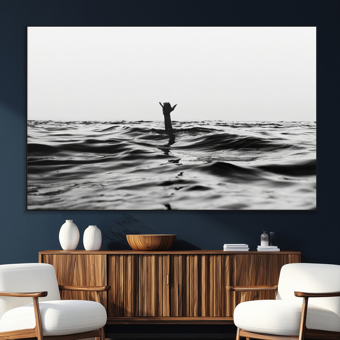 Black and white ocean with a hand making a surfer sign among dark waves, creating a dramatic and minimalist seascape with bold contrast.