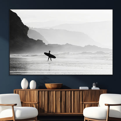 A lone surfer walking along a misty beach with cliffs in the background, carrying their board, capturing a serene and minimal ocean moment.
