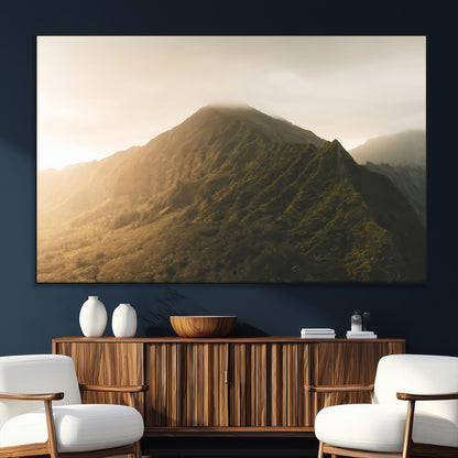 Sunlit mountain peak with mist rolling over its rugged slopes, bathed in golden light, creating a warm and tranquil nature-inspired scene.