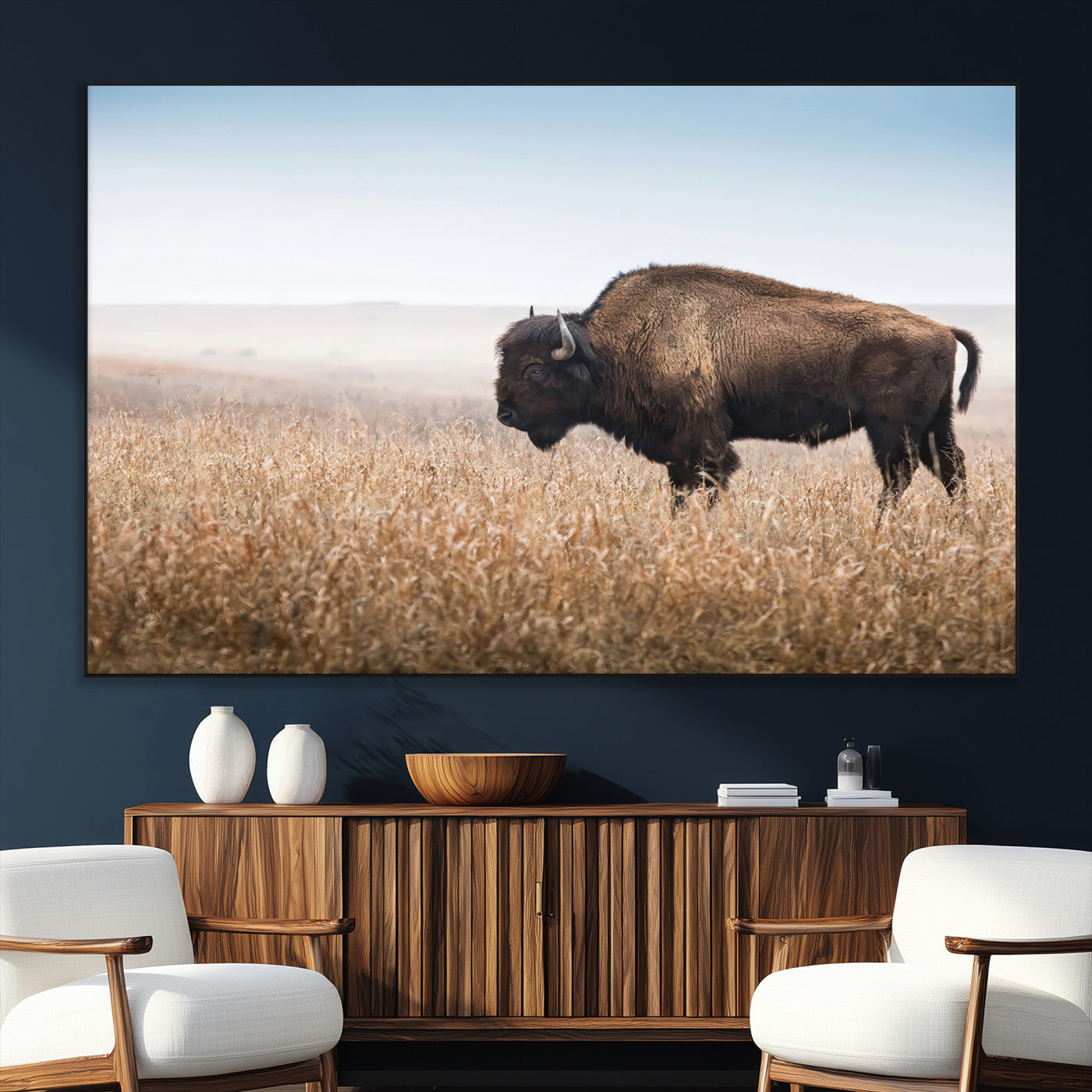A majestic bison standing in an open prairie field, its strong form blending into the golden grass under a vast blue sky, evoking the wild spirit of the American plains.