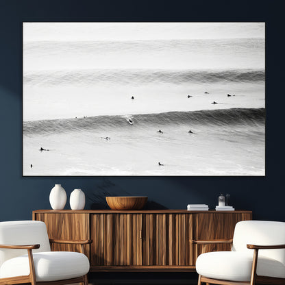 A monochrome photograph of swimmers gliding through gentle ocean waves, evoking a sense of calm and movement.