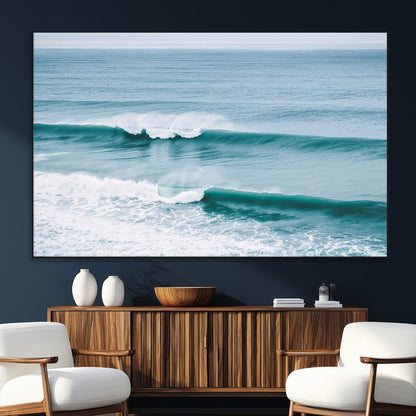 Powerful ocean waves rolling towards the shore, their turquoise hues blending with white sea foam under an open horizon, capturing the essence of the ocean's movement.