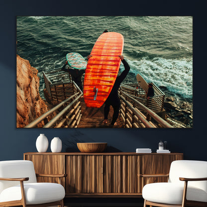 A surfer carrying a bold orange surfboard down a rugged staircase toward the ocean, bathed in golden hour light, capturing the energy of coastal adventure.