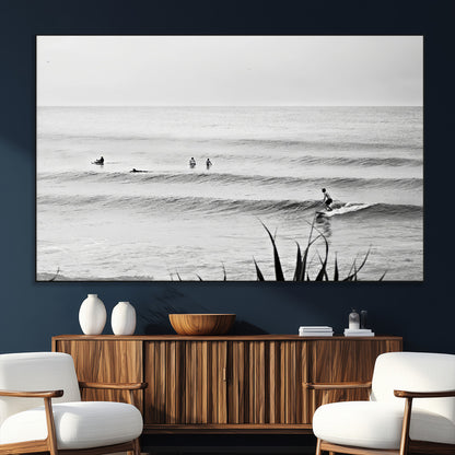 Monochrome canvas of surfers on calm ocean waves, ideal for minimalist coastal or beach-inspired interior decor.