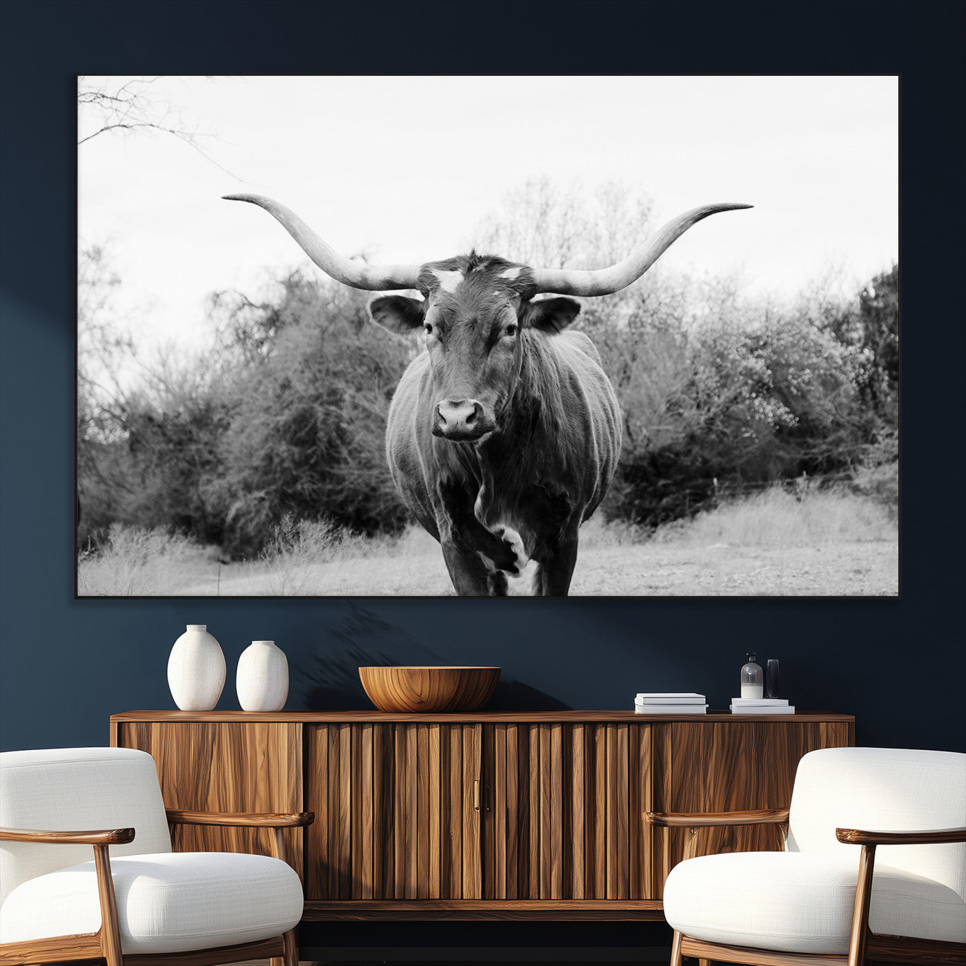 Black and white photo of a longhorn cow in a field, perfect for rustic farmhouse or western-themed interior wall decoration.