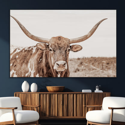 A longhorn cow in soft beige desert tones, standing calmly in open land, perfect for neutral western or rustic farmhouse interiors.