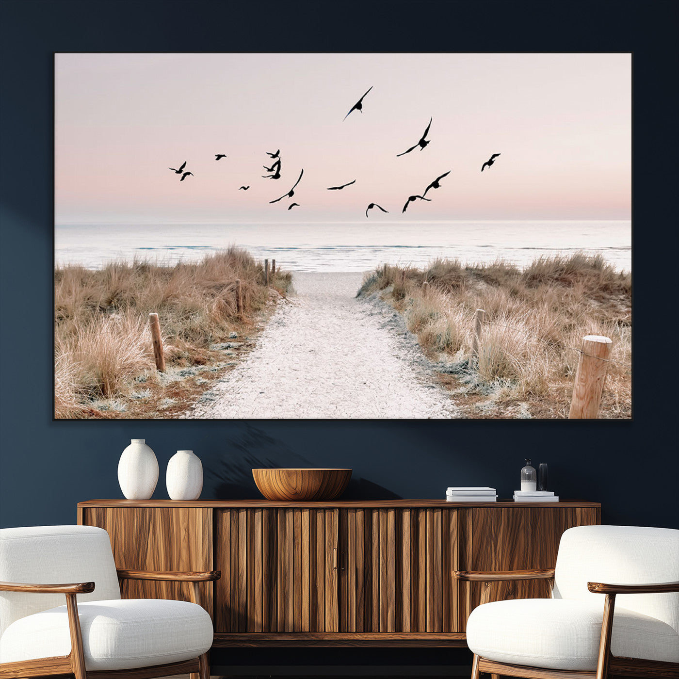 A peaceful coastal pathway leading to the ocean, with birds flying across a soft pastel sky, creating a calm and scenic beach atmosphere.