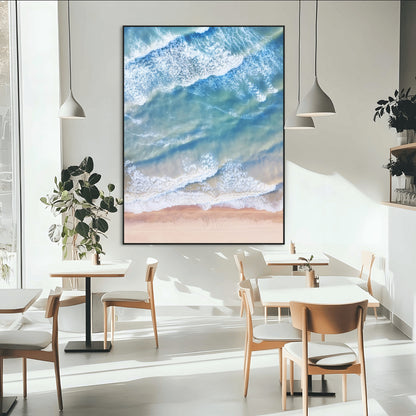 Aerial photo of soft blue waves meeting sandy shore, perfect for modern coastal or beach-themed decor with a light and tranquil aesthetic.