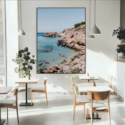 A vibrant coastal photo of a rocky Mediterranean cove with turquoise waters and beachgoers, ideal for boho coastal or summer-inspired interiors.