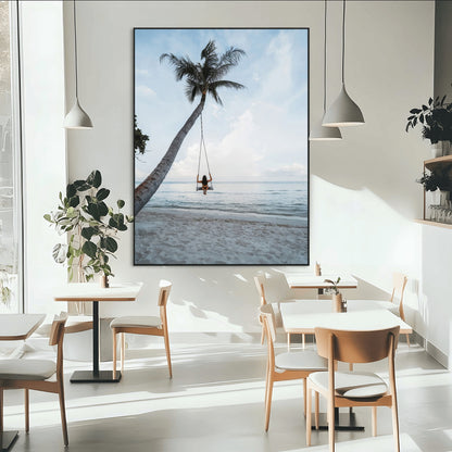 Wall art of a girl on a swing hanging from a palm tree over calm ocean waters, perfect for tropical or minimalist coastal decor.