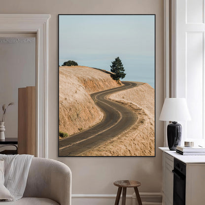 Earth-toned photograph of a winding road through golden hills, ideal for neutral or rustic-themed decor with a calming travel vibe.