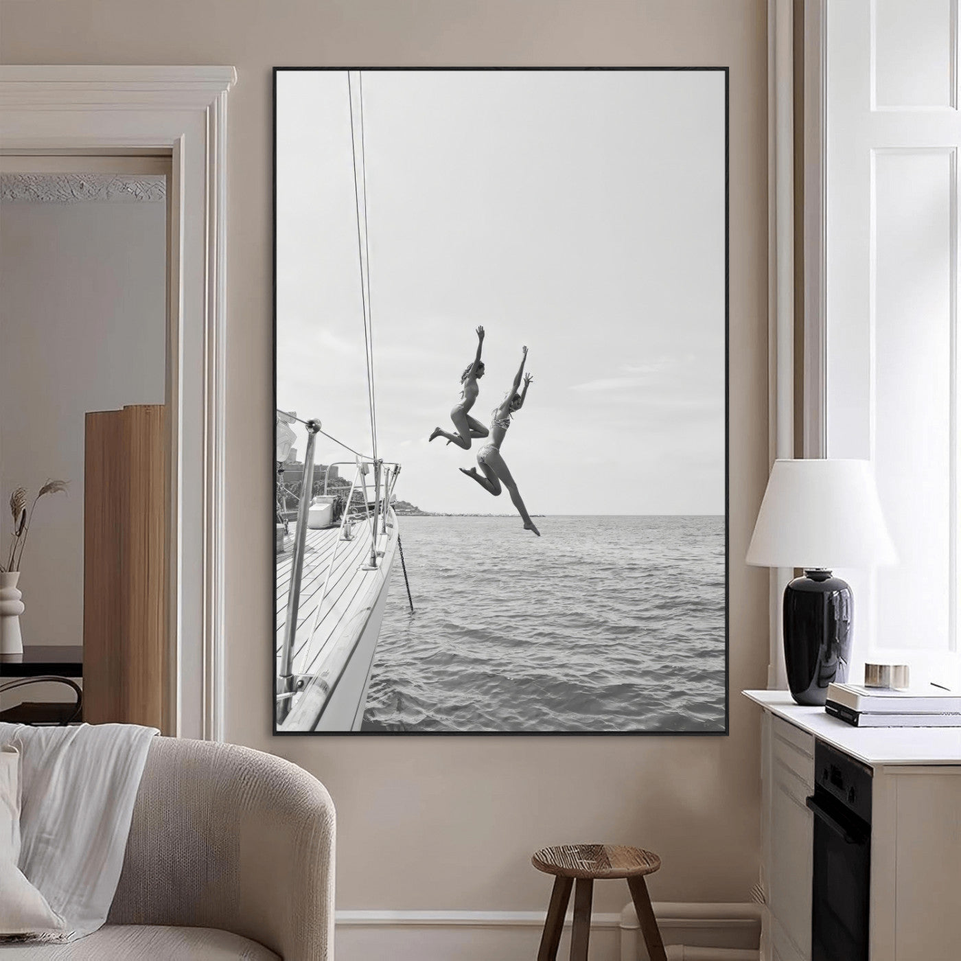 Black and white canvas wall art of two women joyfully jumping off a yacht into the sea, ideal for minimalist coastal or nautical-themed spaces.