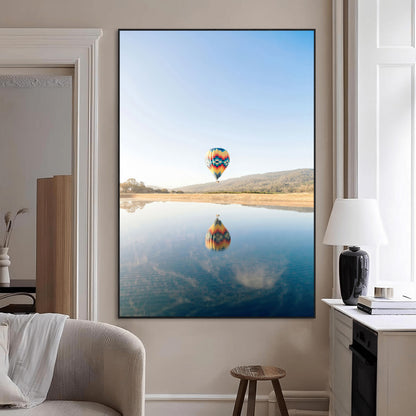 Canvas of a hot air balloon floating above a calm lake with soft reflections and vibrant sky, ideal for modern minimalist or adventure-themed home decor.