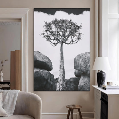 Tall desert tree in black and white, standing between large rocks, perfect for bold and minimalist nature-themed interior spaces.
