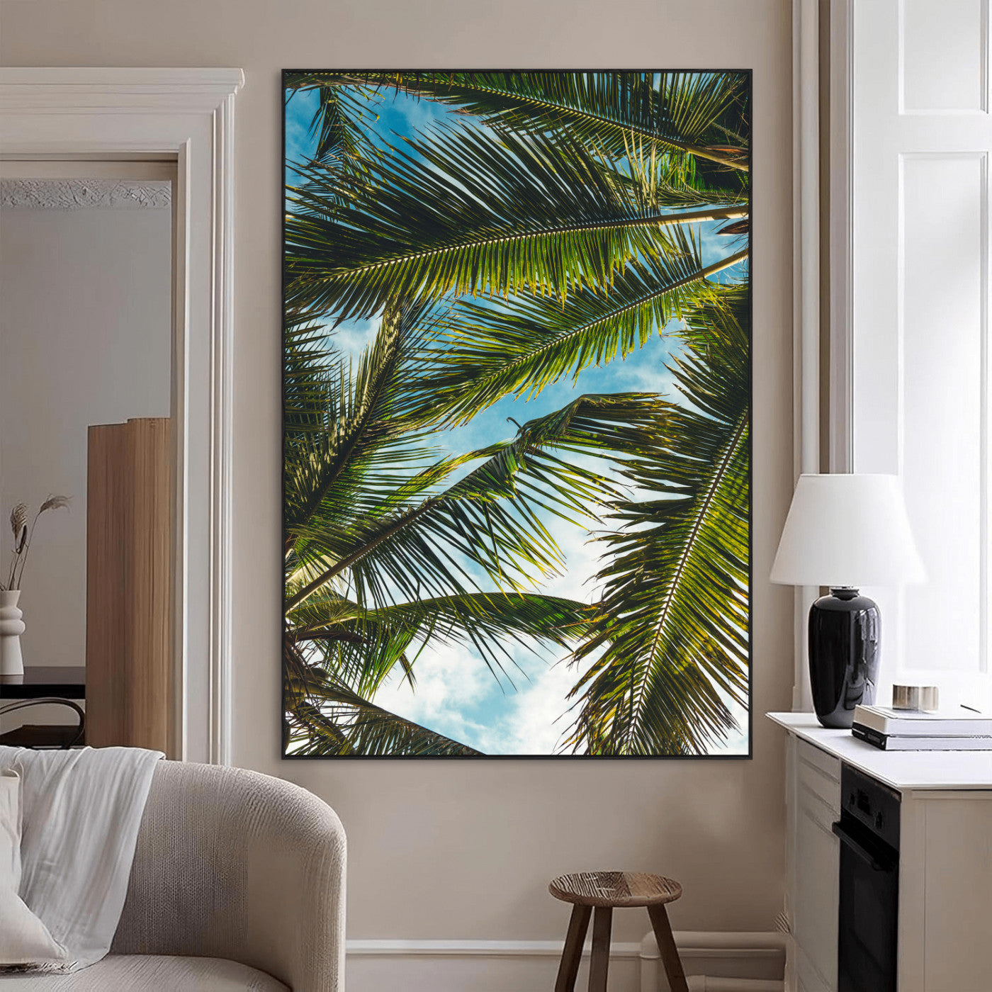 Looking up at lush green palm leaves against a bright blue sky, creating a tropical and relaxing coastal aesthetic.