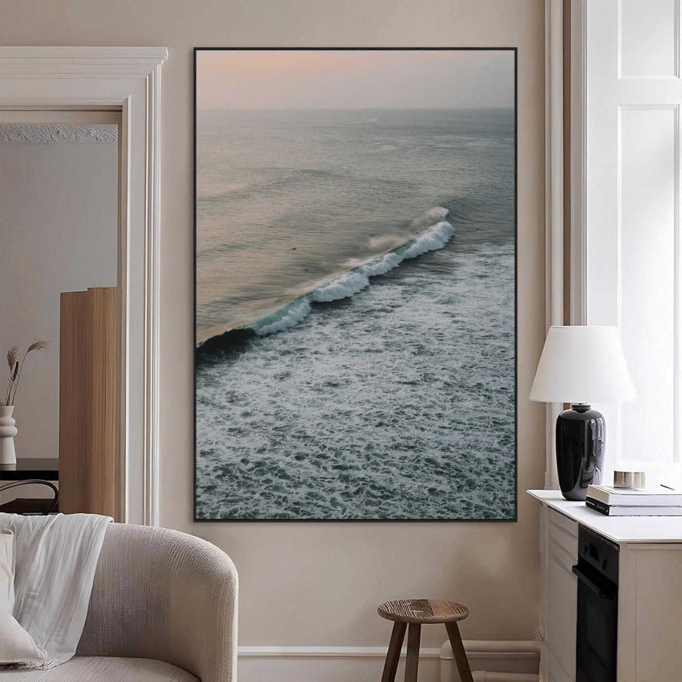Aerial view of ocean waves rolling towards the shore under a soft sunset sky, creating a peaceful and minimalist coastal scene.