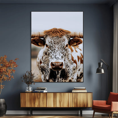 Close-up of a speckled Texas longhorn with wide horns and a bold gaze, perfect for rustic or country-style decor in warm tones.