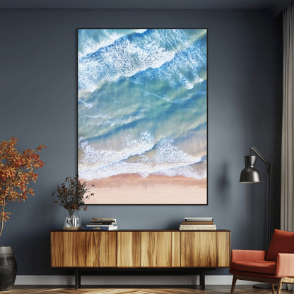 Aerial photo of soft blue waves meeting sandy shore, perfect for modern coastal or beach-themed decor with a light and tranquil aesthetic.