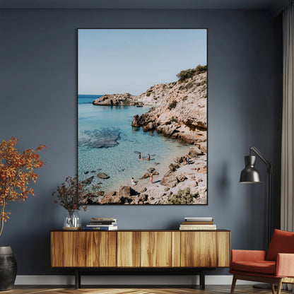 A vibrant coastal photo of a rocky Mediterranean cove with turquoise waters and beachgoers, ideal for boho coastal or summer-inspired interiors.