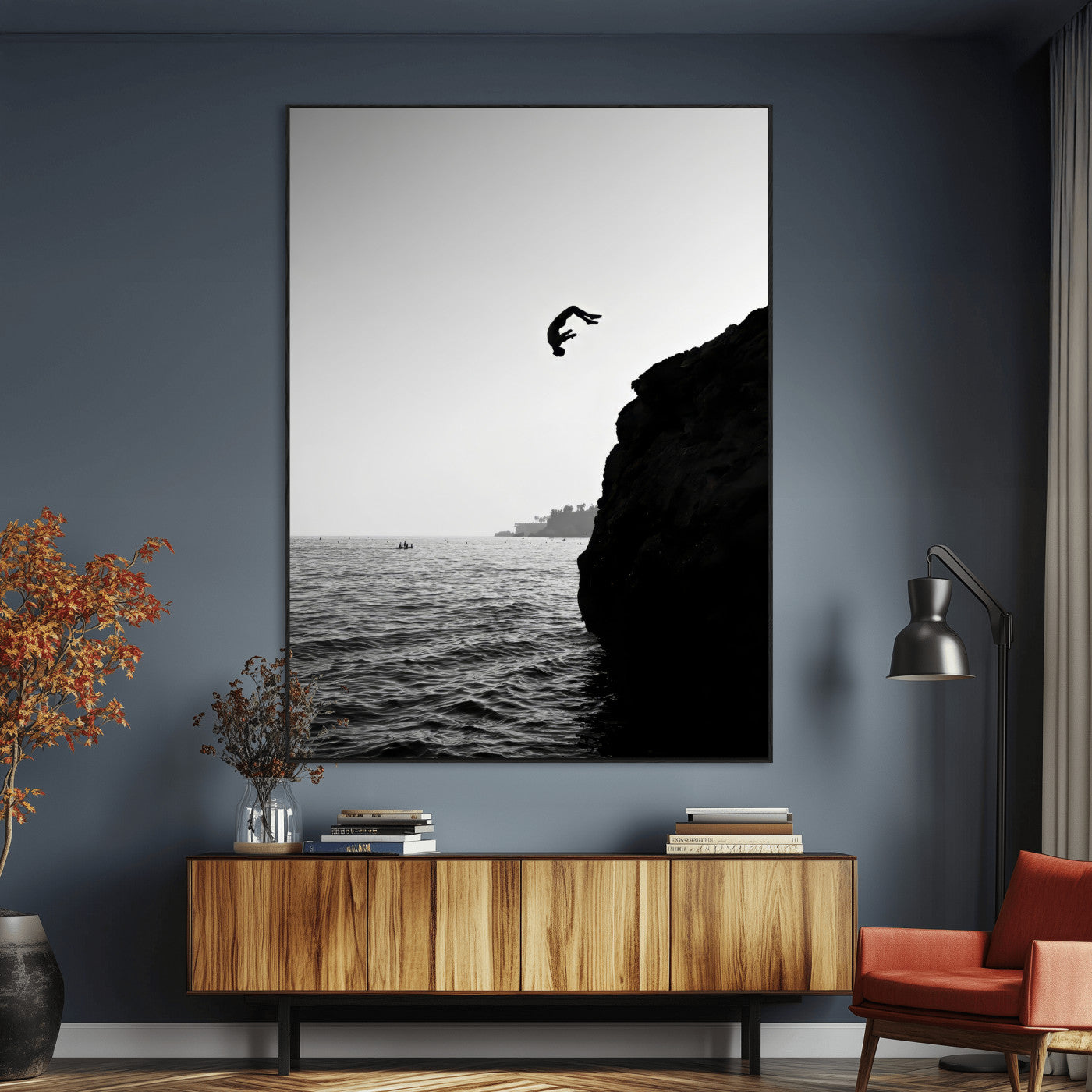 Silhouette of a person mid-air during a cliff jump over the ocean, captured in black and white for minimalist adventure decor.