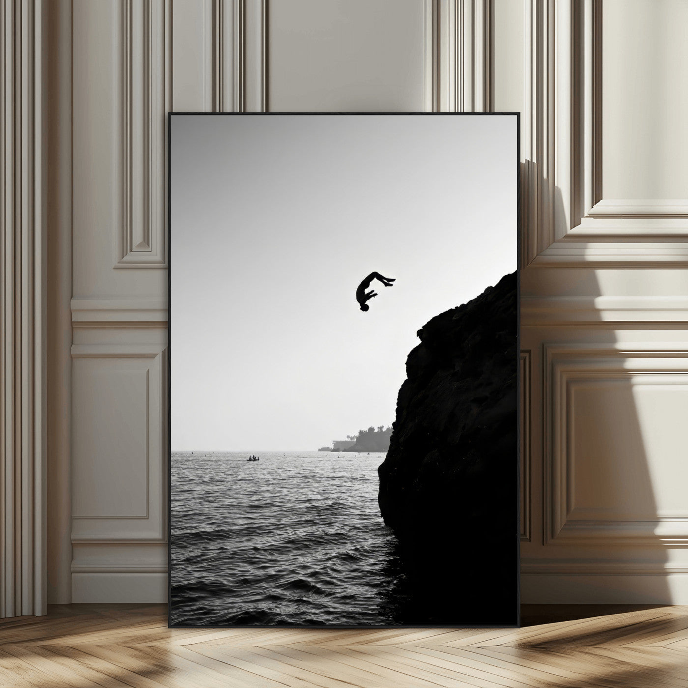 Silhouette of a person mid-air during a cliff jump over the ocean, captured in black and white for minimalist adventure decor.