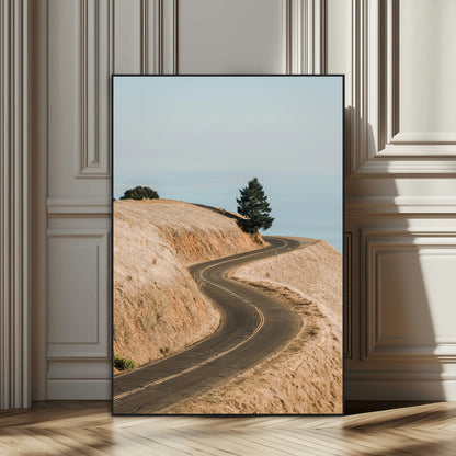 Earth-toned photograph of a winding road through golden hills, ideal for neutral or rustic-themed decor with a calming travel vibe.