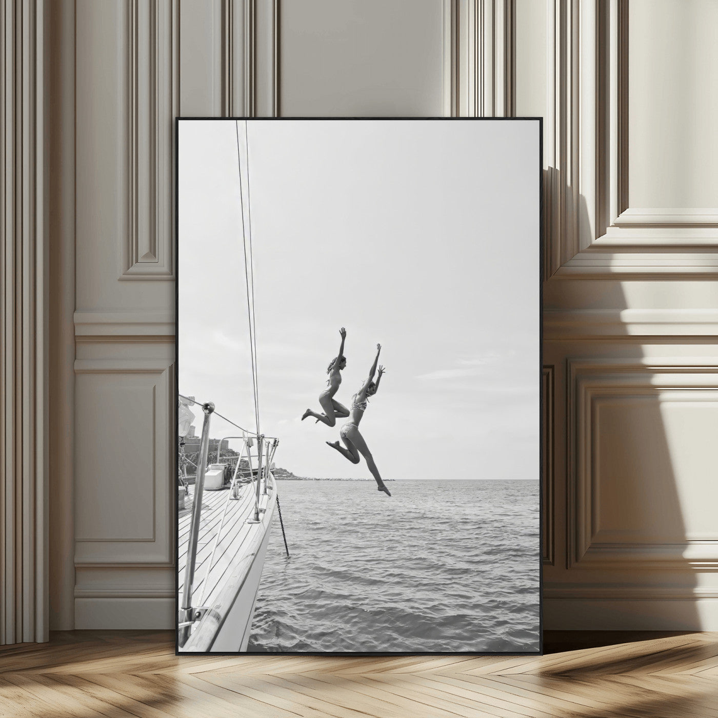 Black and white canvas wall art of two women joyfully jumping off a yacht into the sea, ideal for minimalist coastal or nautical-themed spaces.
