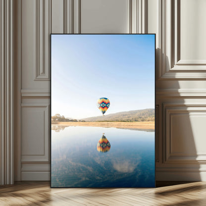 Canvas of a hot air balloon floating above a calm lake with soft reflections and vibrant sky, ideal for modern minimalist or adventure-themed home decor.