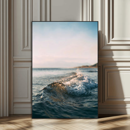 Close-up of ocean waves rolling gently toward the shore at sunset, creating a peaceful and minimalist coastal scene.