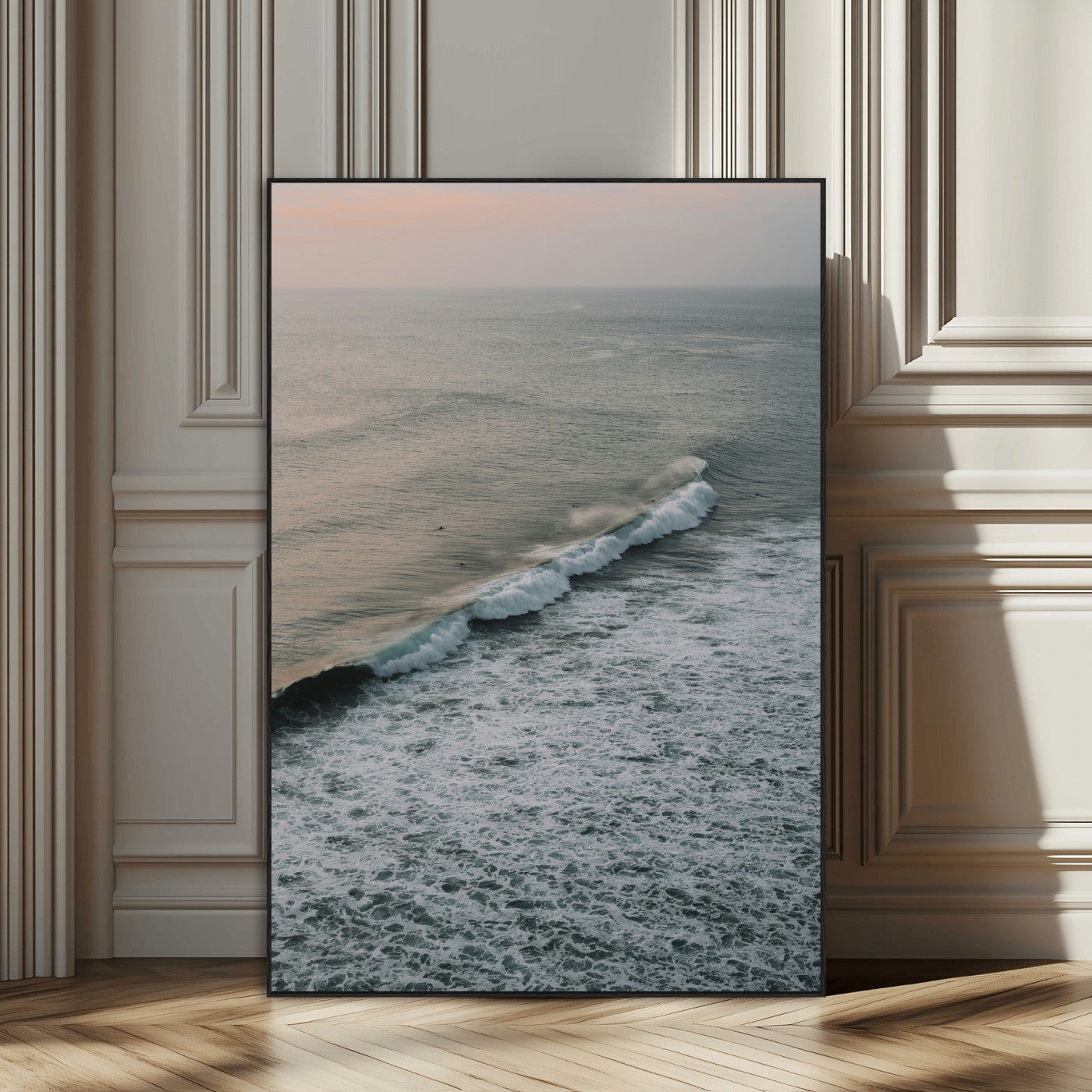 Aerial view of ocean waves rolling towards the shore under a soft sunset sky, creating a peaceful and minimalist coastal scene.