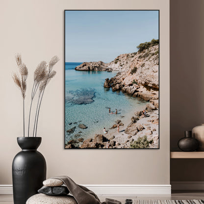 A vibrant coastal photo of a rocky Mediterranean cove with turquoise waters and beachgoers, ideal for boho coastal or summer-inspired interiors.