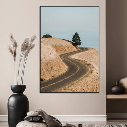 Earth-toned photograph of a winding road through golden hills, ideal for neutral or rustic-themed decor with a calming travel vibe.