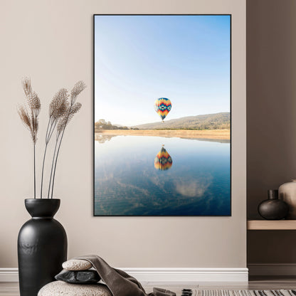 Canvas of a hot air balloon floating above a calm lake with soft reflections and vibrant sky, ideal for modern minimalist or adventure-themed home decor.