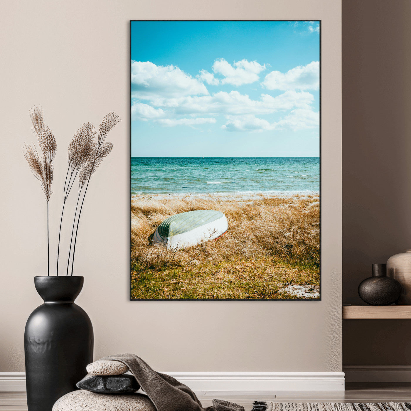A small boat resting on a grassy shore with ocean waves and a bright blue sky, creating a peaceful coastal atmosphere.