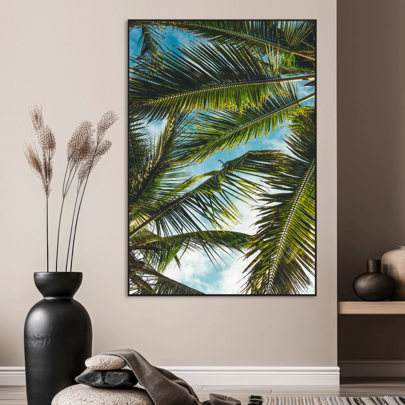 Looking up at lush green palm leaves against a bright blue sky, creating a tropical and relaxing coastal aesthetic.