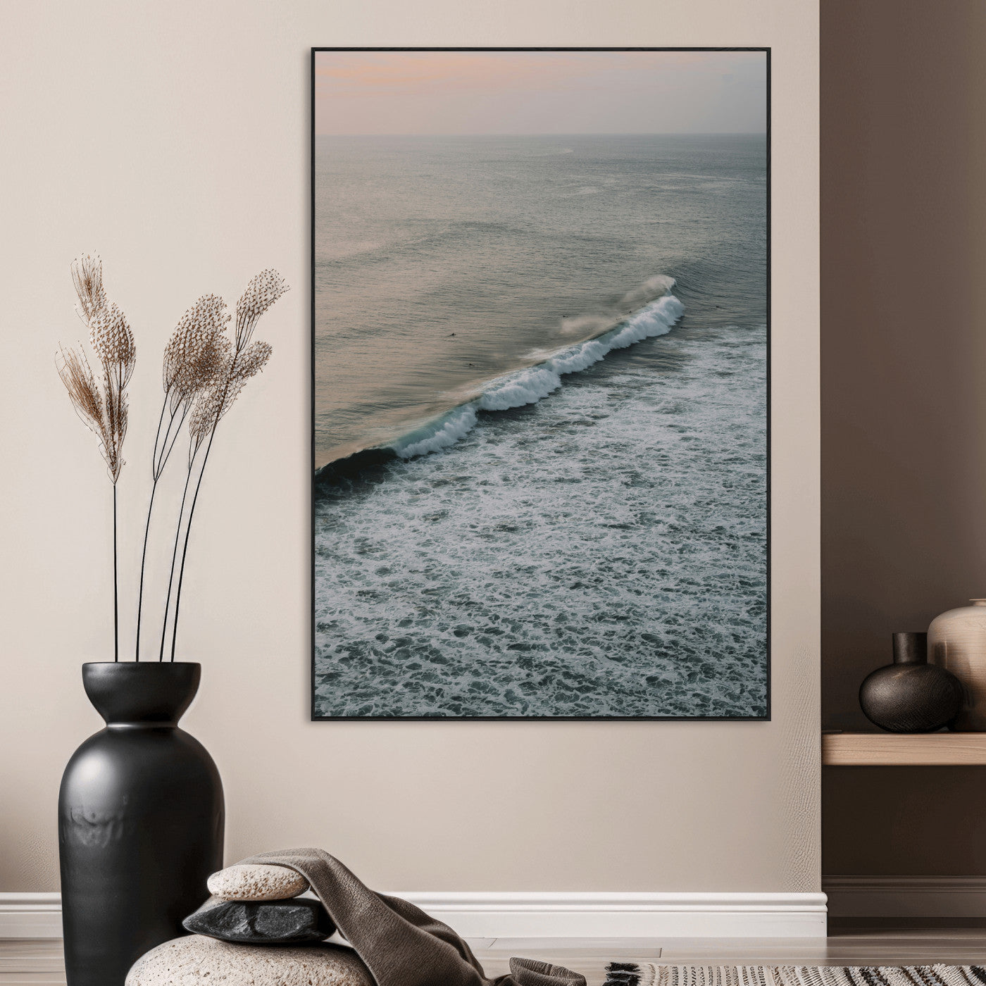 Aerial view of ocean waves rolling towards the shore under a soft sunset sky, creating a peaceful and minimalist coastal scene.
