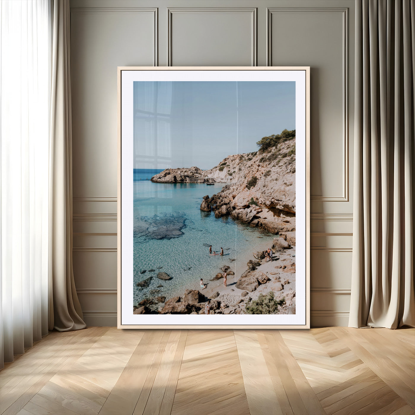 A vibrant coastal photo of a rocky Mediterranean cove with turquoise waters and beachgoers, ideal for boho coastal or summer-inspired interiors.