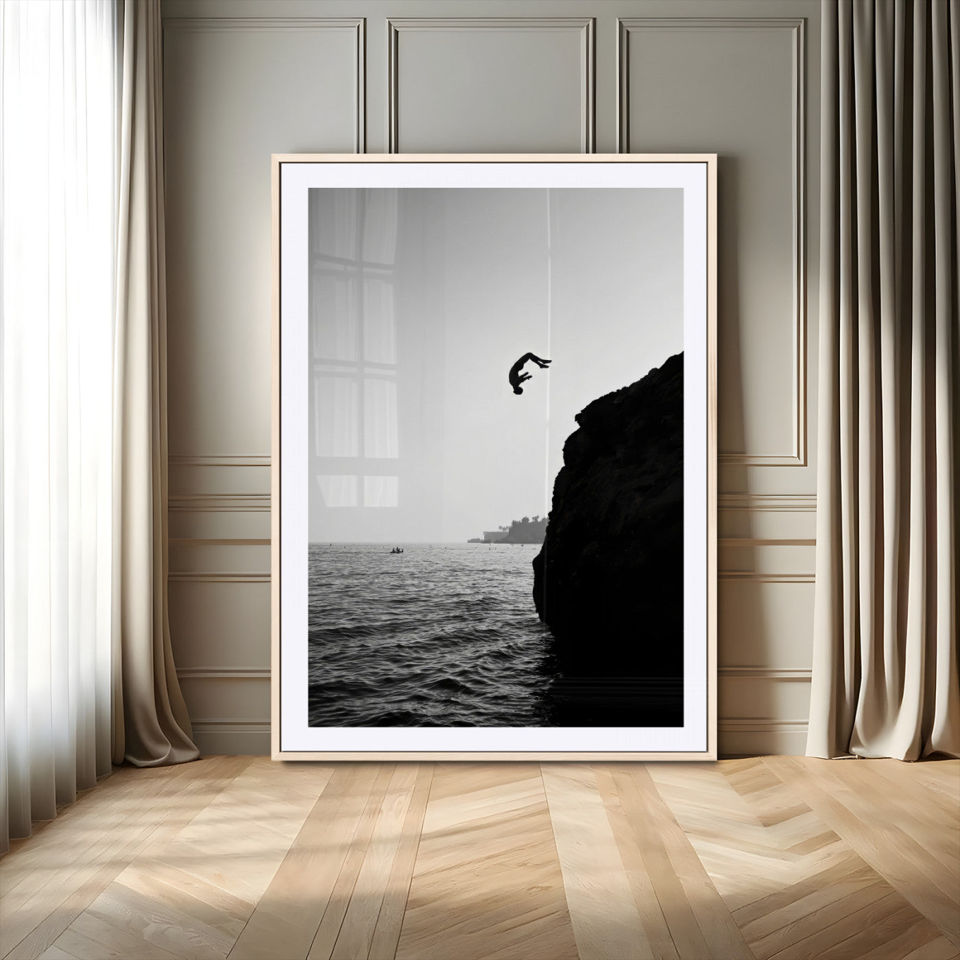 Silhouette of a person mid-air during a cliff jump over the ocean, captured in black and white for minimalist adventure decor.