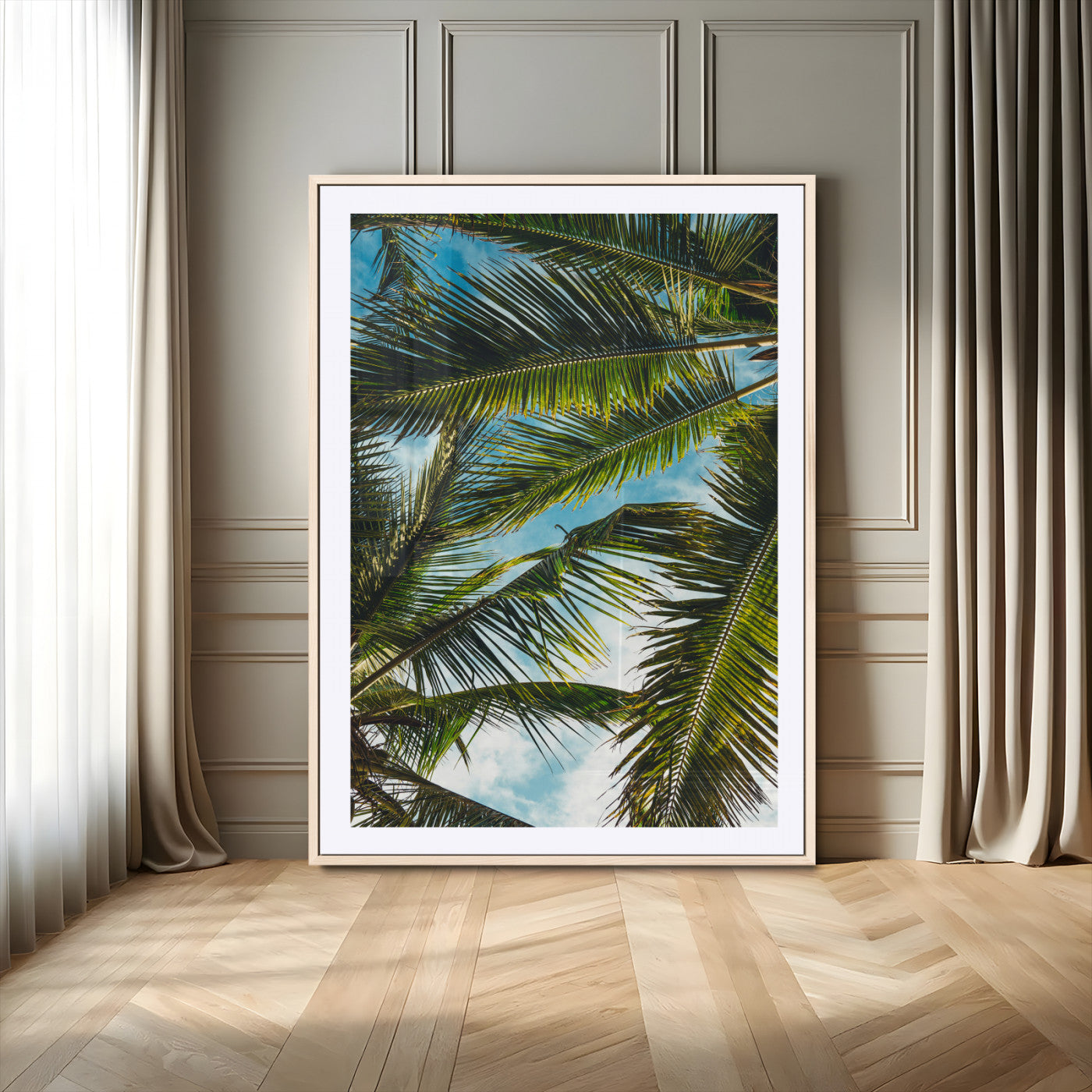 Looking up at lush green palm leaves against a bright blue sky, creating a tropical and relaxing coastal aesthetic.