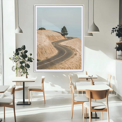 Earth-toned photograph of a winding road through golden hills, ideal for neutral or rustic-themed decor with a calming travel vibe.