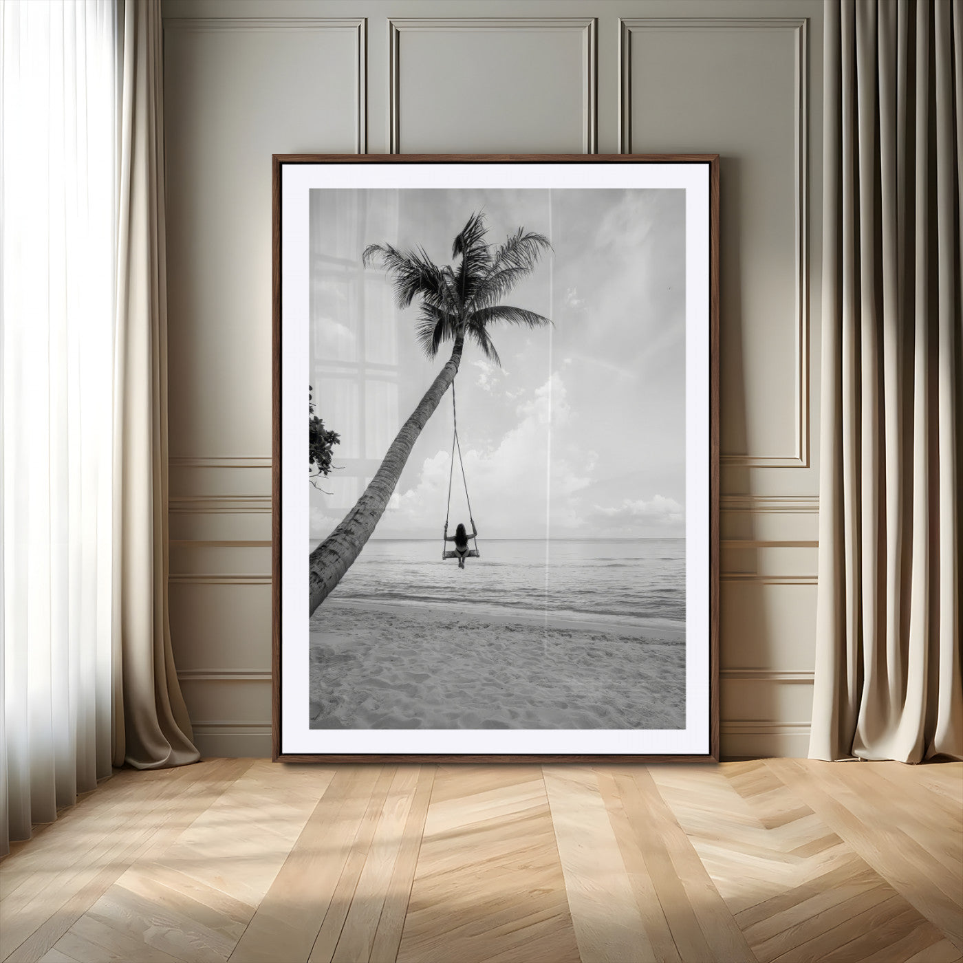 Monochrome photo of a woman swinging from a palm tree on a serene beach, ideal for minimalist or tropical coastal decor.